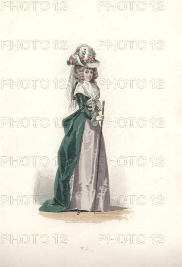 Fashionable woman in flowery chapeau and veil, wearing a fichu and green velvet redingote over a grey silk dress and holding a cane. Era of Marie Antoinette. Handcolored engraving by A. Lacourriere after an illustration by Francois-Claudius Compte-Calix from Costume de l’Epoque de Louis XVI. Paris, 1869.